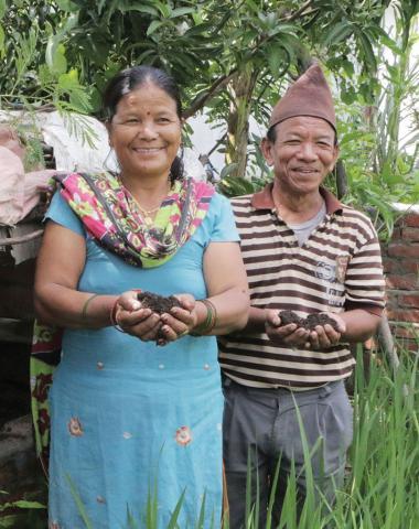 A Nepalese couple holding soil